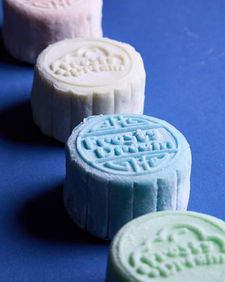 Close-up of three snowskin gelato mooncakes in a row, showing the smooth pastel shells and surface detail.