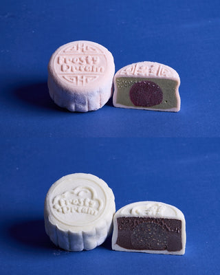 Cross-section of two snowskin gelato mooncakes side by side. Left: pale pink Pistachio Bloom shell with pistachio gelato and raspberry filling. Right: ivory Mocha Nut shell with milk chocolate gelato and coffee filling.